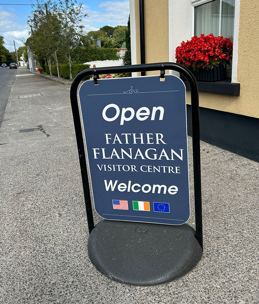 Sign outside Father Flanagan Visitor Centre reads 'Open. Faather Flanagan Visitor Centre. Welcome'.